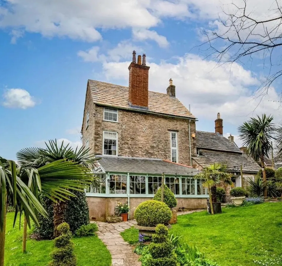 Garden view of the listed stone house in Swanage with its completed Purbeck stone roof