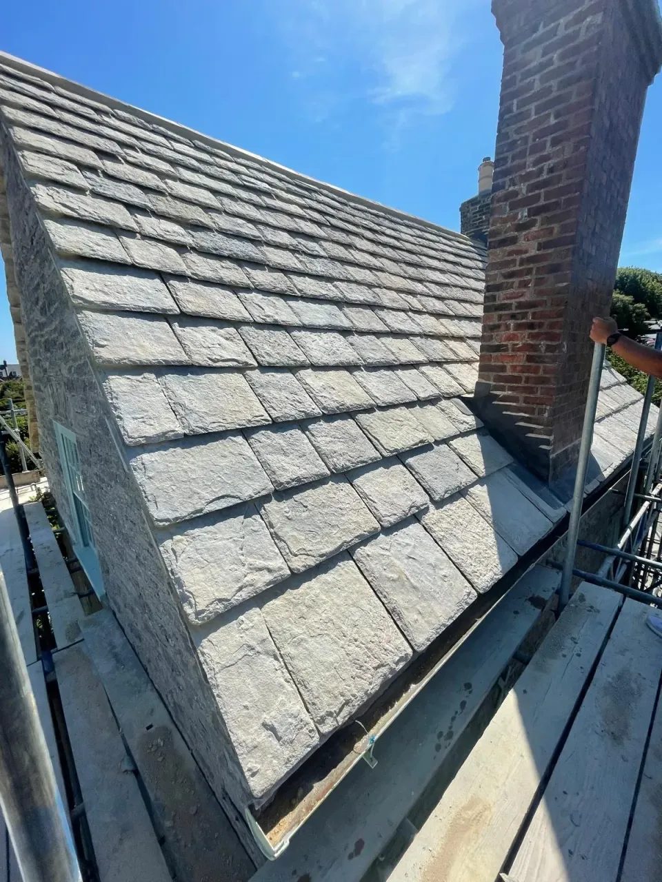 Finished stone roof, brick chimney and eaves gutter on the listed Swanage building