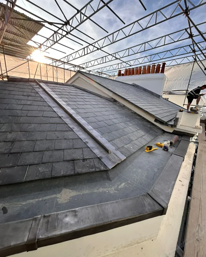 Natural slate roof in Swanage with lead mop roll ridge and scaffold access